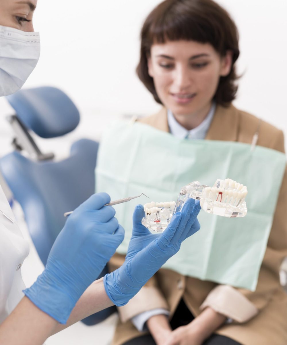 female-patient-looking-dental-mold-with-orthodontist